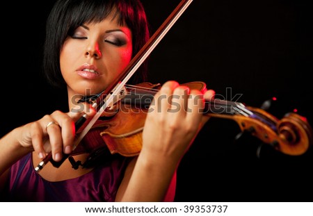 beautiful woman is playing a violin on black background
