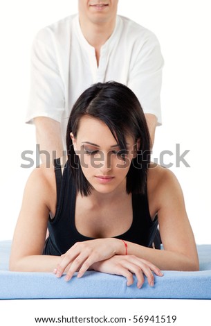 Young woman receiving lower back thai massage from a man, eyes closed
