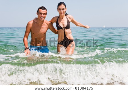 Young happy couple hugging going out of sea