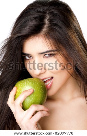 Close-up of beautiful young female biting granny smith apple, looking at camera