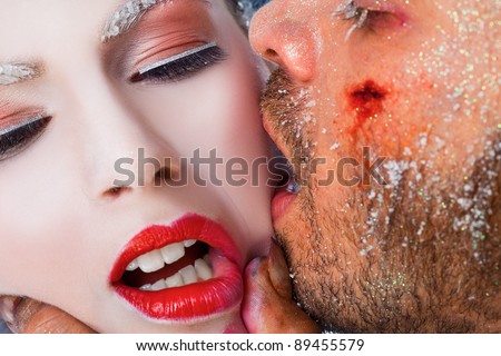 Close-up of wounded male face kissing woman on cheek, both faces covered with frost