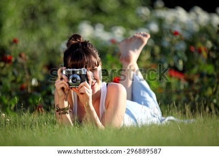 Young woman taking a picture with a vintage camera