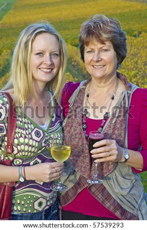 Mother and daughter drinking wine at a winery in vertical composition