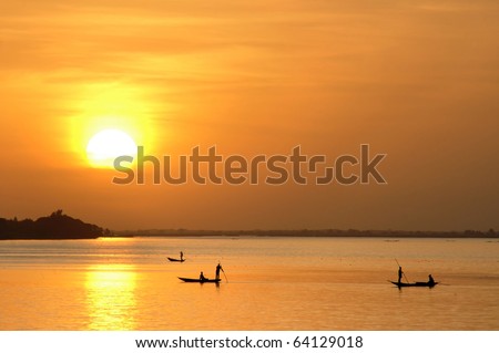Horizontal of African fishermen in canoes at sunset