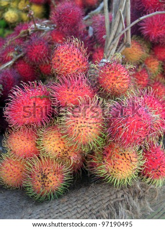 A close up of a bunch of lychees for sale at a market