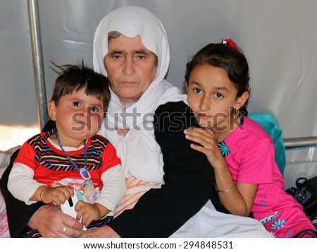 KANKE REFUGEE CAMP, DOHUK, KURDISTAN, IRAQ - 2015 JULY 4  - A Yazidi grandmother and her two child who escaped from ISIS inside her tent in Kanke refugee camp.