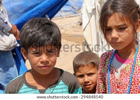 BAHARKA REFUGEE CAMP, ERBIL, KURDISTAN, IRAQ - 2015 JULY 1  - Three displaced children  in Baharka refugee camp. Baharka is home to more than 740 refugee families.