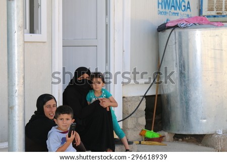 RWANGA REFUGEE CAMP, ZAKHO, KURDISTAN, IRAQ - 2015 JULY 13 - Family sitting outside their temporary home in Rwanga (rwanga refugee) camp