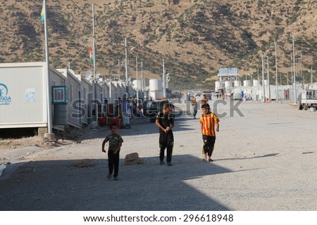 RWANGA REFUGEE CAMP, ZAKHO, KURDISTAN, IRAQ - 2015 JULY 13 - Young refugees walking down the main street in Rwanga (rwanga refugee) camp depict