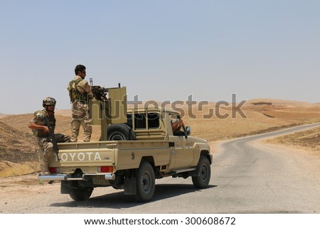 BASHIK FRONTLINE, KURDISTAN, IRAQ - 2015 JULY 25  - Two unidentified kurdish (peshmerga) fighters in back of truck at BASHIK (bashik) base 25km from ISIS controlled Mosul.