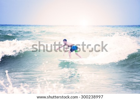 surfer throws a huge plume of spray as he executes on patong puket thailand,vintage Instagram retro hipster