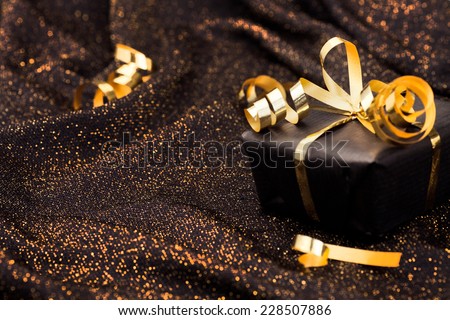 Black gift box on black shiny background.