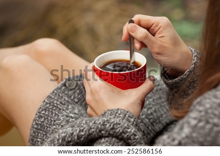 Morning coffee. Woman holds a red coffee cup