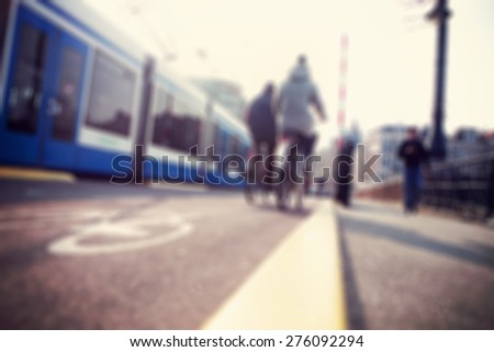 City commuters. High key blurred image of people riding a bike in the street. Unrecognizable faces.
