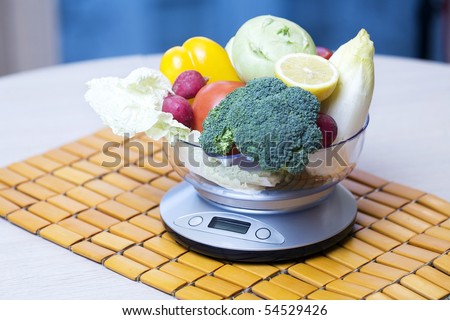 Fresh vegetables with kitchen scales