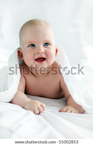 Baby looking out from under blanket