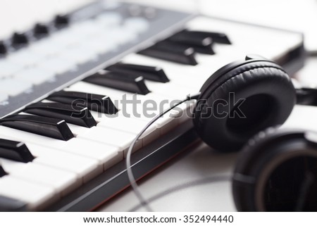 creativity. headphones and keyboard. production of electronic music.\
Piano keyboard with headphones for music