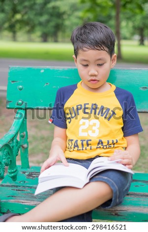 child reading a book in garden