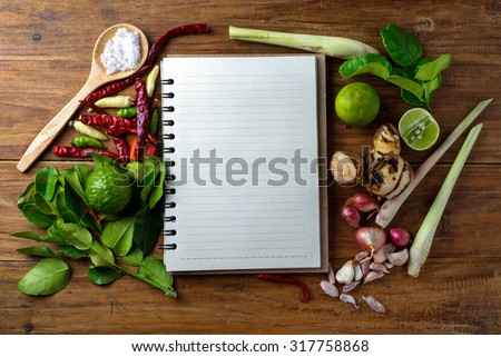 recipe book with fresh herbs south asia and spices on wooden background, thai food.