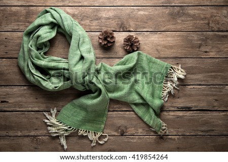 warm scarf on rustic with pine corn wooden background. Top view