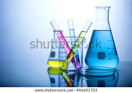 Different laboratory glassware with color liquid and with reflection.