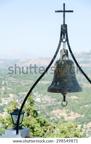A small bell with a cross at the top