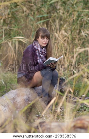 young girl reading a book on nature