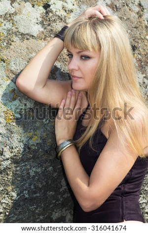 Girl on a walk, a blonde with blue eyes, everyday make-up, portrait of a young girl, extravagant fashion, long hair, the texture of natural stone.