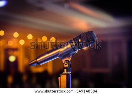 Wireless microphone stand on the stage venue with blur bokeh background