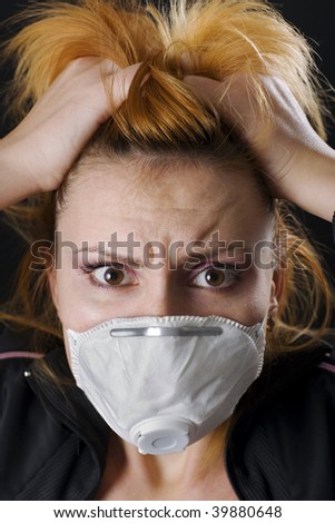 Woman wears a face mask and medical scrubs with a wide-eyed expression of concern or fear