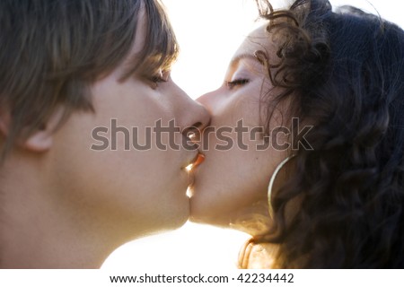 Portrait of a hot young couple kissing (close up).