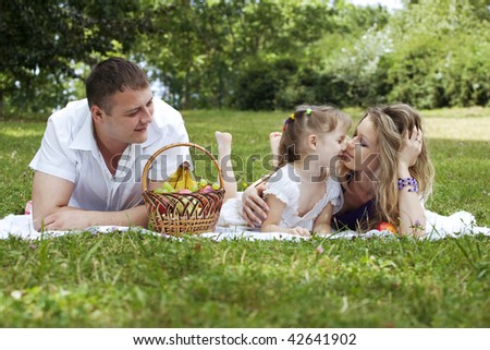 Family sharing moments together on the picnic in the meadow.