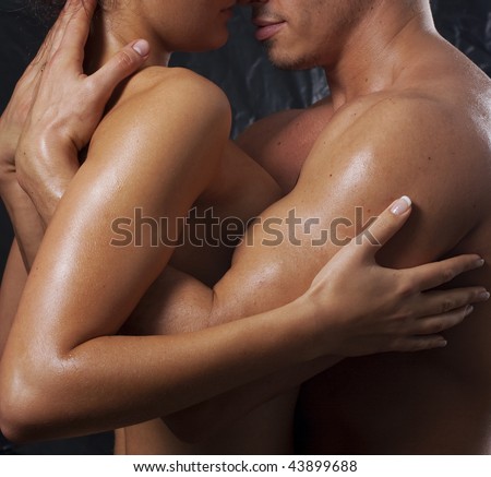Loving affectionate nude heterosexual couple engaging in sexual games, hugging and kissing