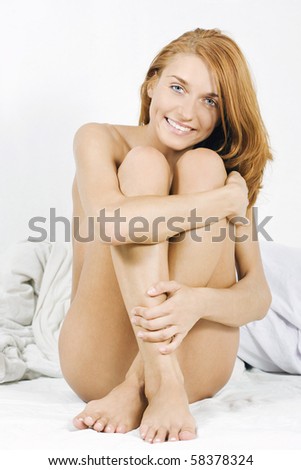 stock photo Happy sexy naked girl sitting on bed