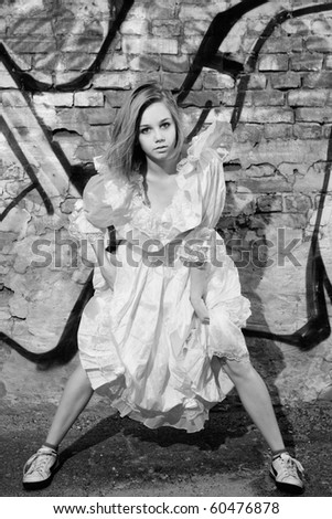 Beautiful young fashion model in pink dress against the wall with graffiti