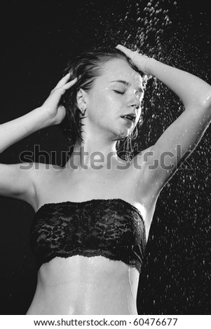 A young attractive woman is covered with dripping water.