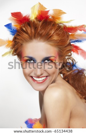 eye makeup with feathers. stock photo : Beautiful woman with face framed in feathers with bright makeup and long faux