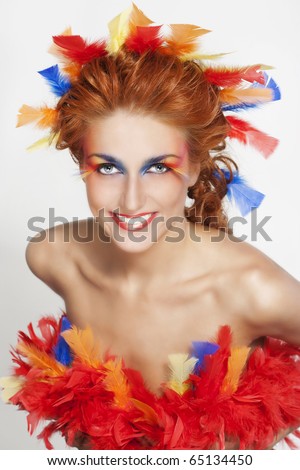 eye makeup with feathers. stock photo : Beautiful woman with face framed in feathers with bright makeup and long faux