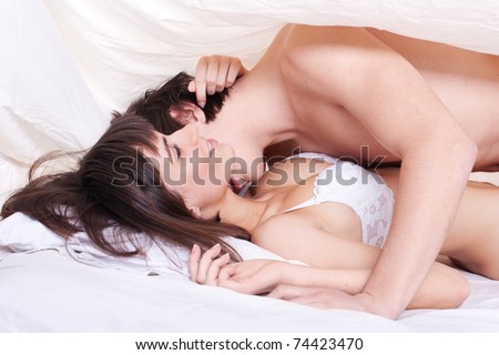 stock photo Young sexy couple making love in bed under the blanket