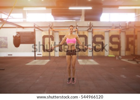 beautiful sporty woman workout with jumping rope in crossfit gym