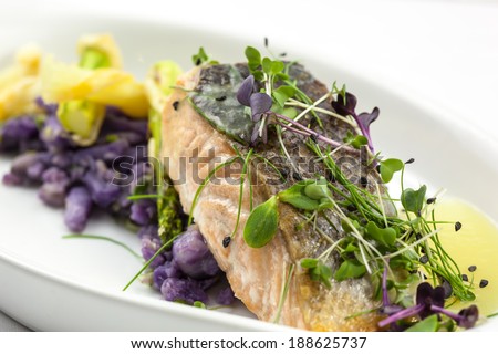 Salmon filet on white wine sauce, served with asparagus baked in puff pastry and purple potatoes