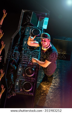 Charismatic disc jockey at the turntable. DJ plays on the best, famous CD players at nightclub during party.