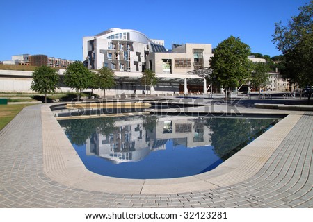 The Scottish Parliament, Holyrood, Edinburgh, Scotland with the modern design reflected in the water feature at the front of the building.