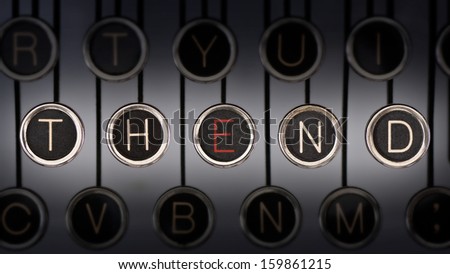 Close up of old manual typewriter keyboard with scratched chrome keys that spell out \