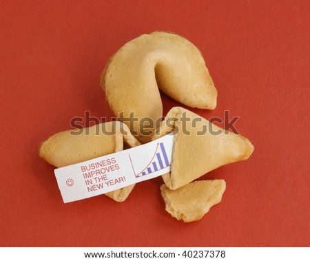 Two fortune cookies on a red background. One is opened, showing a fortune saying, \