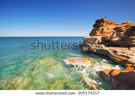 Red cliffs at Gantheaume Point, Broome, Western Australia on a bright and sunny day.