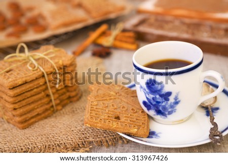 A cup of coffee with traditional Dutch speculaas. Authentic wooden cookie cutters especially made for these cookies can be seen in the background.