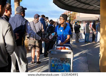 BERKELEY,CA-SEPT 21: Apple employee hands out food to line of customers waiting to buy the new iPhone 5 at the Apple store in Berkeley, CA on Sept. 21, 2012. Some camped overnight to stake out a spot.