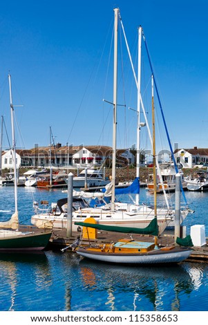 Small yacht harbor in Port Townsend, Washington.  Sunny day with reflections of sailboats in the clear water.