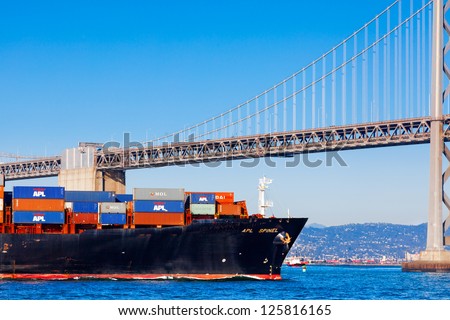 SAN FRANCISCO-AUG 11: A loaded cargo ship in the SF Bay heads under the Bay Bridge toward the Oakland Container Port, in San Francisco on Aug. 11, 2012.  The port is the 4th busiest in the nation.